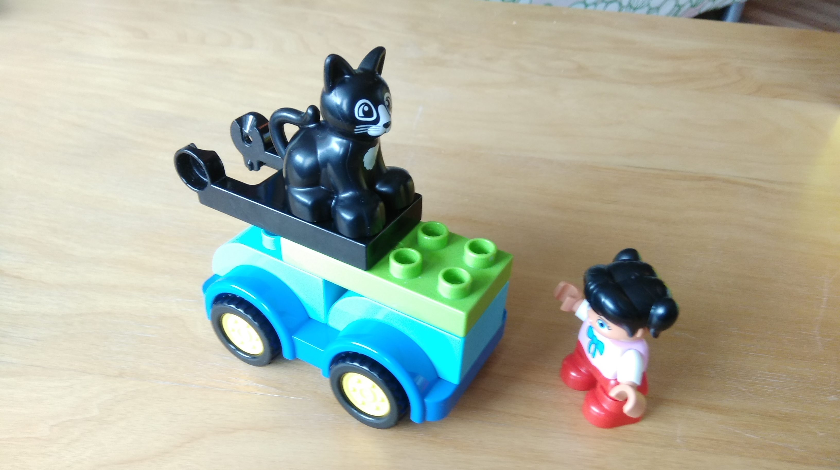 Spielzeugbild: Legoauto mit Katze und Kind